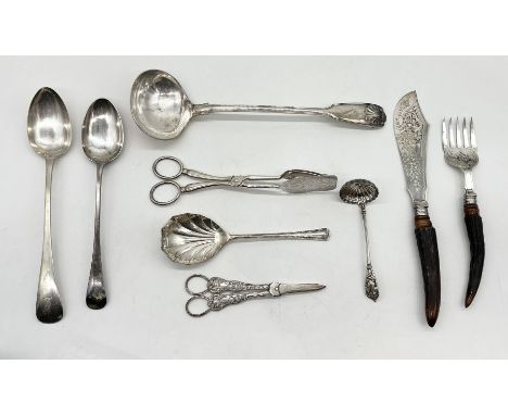 A silver plated ladle, two serving spoons, horn handled fish servers along with other silver plated cutlery, grape scissors e