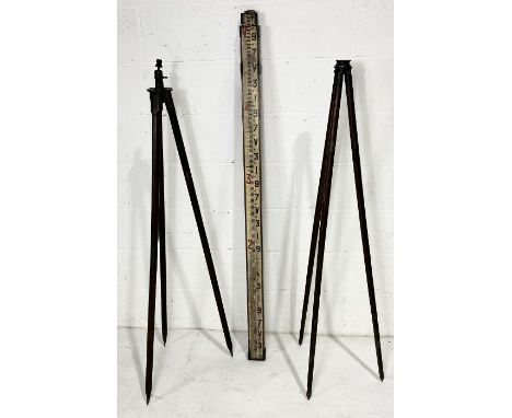 Two vintage tripod theodolite stands along with an extending scale 