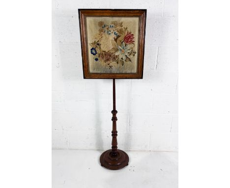 A Victorian pole screen with tapestry decoration. 