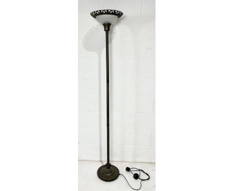 A modern metal standard lamp with column detail and glass shade 