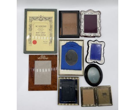 An assortment of picture frames, along with a vintage European travel wallet.