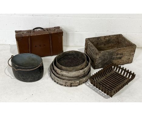 A collection of various items including a vintage leather suitcase, garden sieves, cast iron fire grate, vintage jam crate et