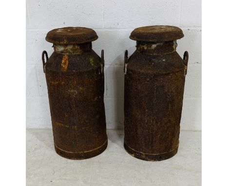 Two vintage weathered lidded milk churns - one lid marked UCL Trowbridge