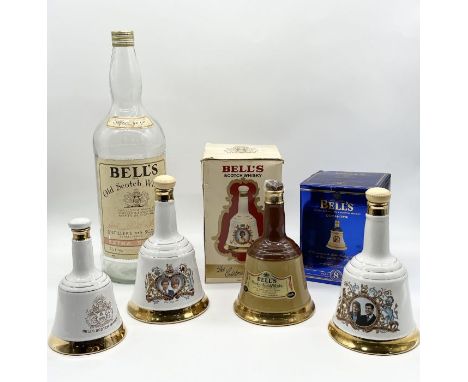 A collection of ceramic decanters including Wade, Bell's etc. along with an oversized Bells Whisky bottle 