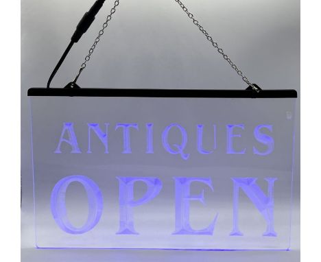 A small light-up neon blue "Antiques Open" sign 