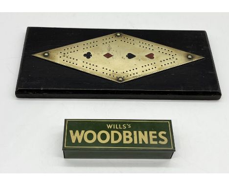 An oak and brass cribbage board decorated with the suits along with a set of Wills Woodbine dominoes 