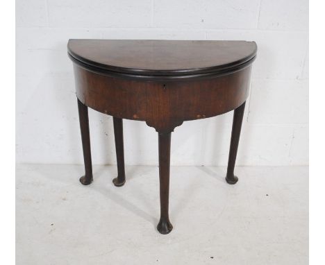 A Georgian mahogany folding card table, with lift up top to reveal storage under, raised on pad feet - diameter 75cm, height 