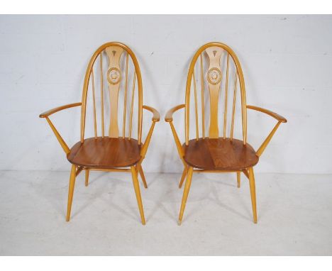 A pair of Ercol blonde 'swan back' arm chairs