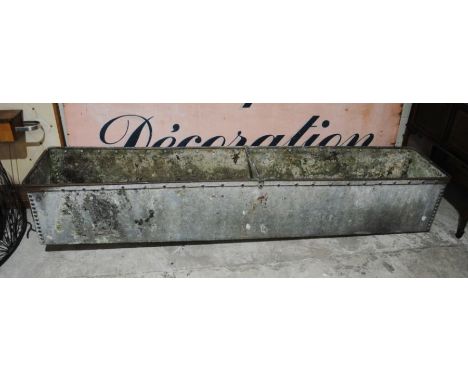 A large weathered galvanised animal feeding trough - length 243cm, depth 47cm, height 42cm