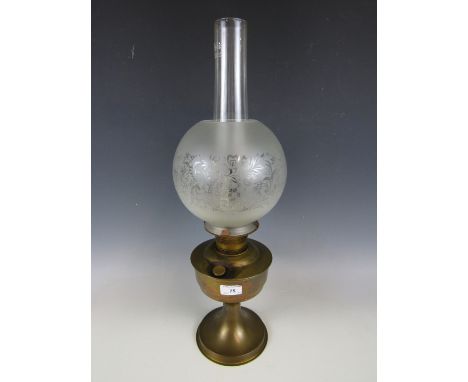 A brass oil lamp with etched glass shade
