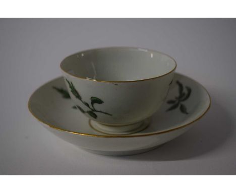 A Worcester tea bowl and saucer painted in green with floral sprigs (hairline to saucer)