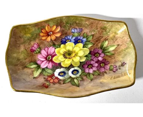 A Royal Worcester shaped small dish, painted with a floral spray, signed E Barker, 10cm long