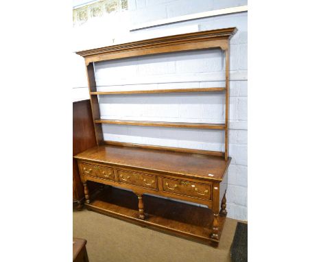 Bylaw - a reproduction oak and burr oak dresser with moulded cornice over an open two shelf plate rack, the base with three d