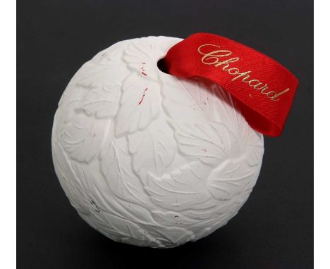 A Chopard Christmas bauble, relief moulded white ceramic with red branded ribbon, 9cm diameter