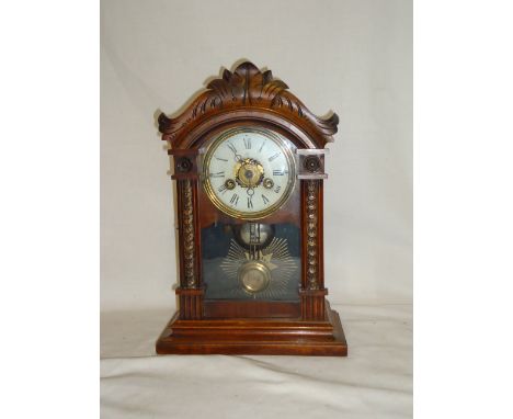 A Junghans Mantel Clock with white dial and glazed door, in carved wooden case, 14" (36cms) high.