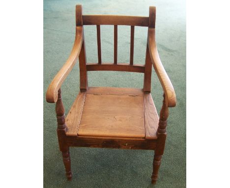 A Child's 19th century elm Commode Elbow Chair with rail back, lifting seat and ring turned supports.