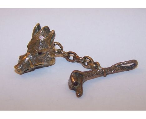 A gilt metal Fob in the form of a wild boar head with stone set eyes, joined to a hunting whip with a dog's head and stone se