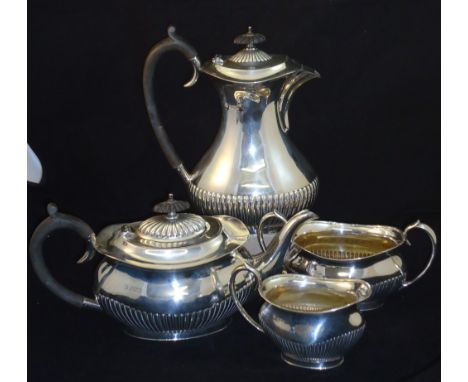 A silver four piece Teaset of oval design with half body reeded decoration, the teapot and hot water jug with black wood hand