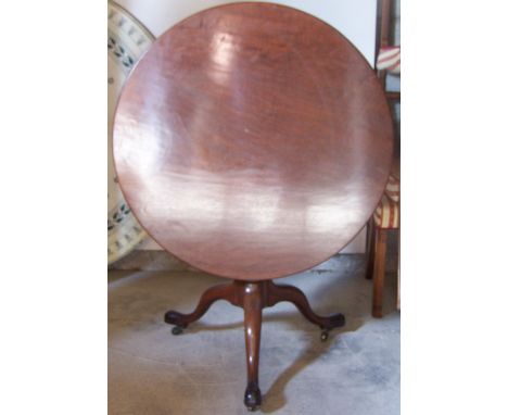 An early 19th century mahogany circular tilt-top Breakfast Table on a bird cage bracket, gun barrel column and triple splay s