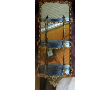 An ebonised and gilded Wall Bracket with mirrored back, open shelves and rococo style mounts, 29" (74cms) x 13" (33cms).