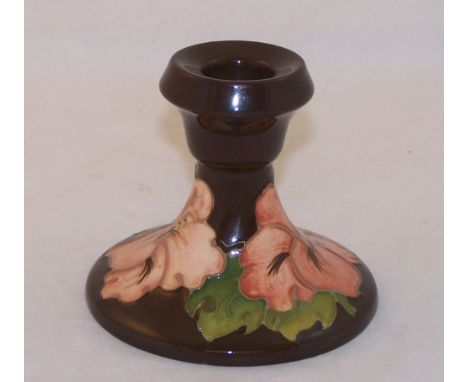 A Walter Moorcroft Hibiscus pattern Candlestick with a brown ground and Moorcroft Museum label to base, 3 1/2" (9cms) high.