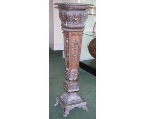 An early 20th century metal Pedestal of 18th century design with mask and foliate decoration on a tapering square column and 
