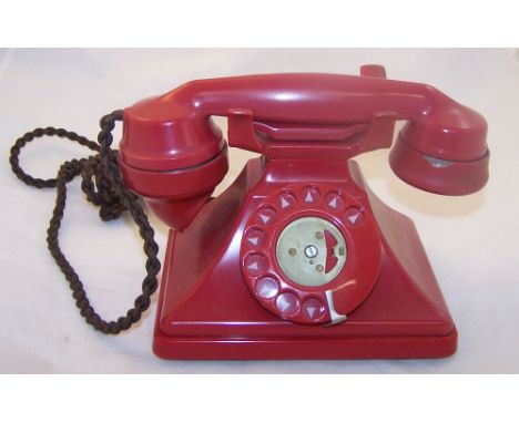 A vintage Telephone of swept design in red Bakelite case and with original twisted flex.