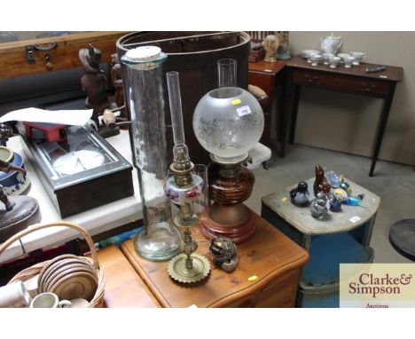 A glass oil lamp with opaque glass shade together with one other oil lamp with floral glass reservoir; a glass storage jar et