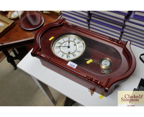 A reproduction mahogany two hole wall clock