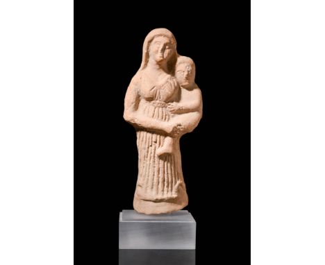 Ca. 600 BCA hollow terracotta figure of a mother goddess holding a child in her arms. The goddess is depicted wearing a belte