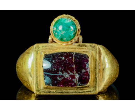Ca. AD 400 - 600 A massive Byzantine gold ring with double bezel, set with garnet and emerald. The terminals join a rectangul
