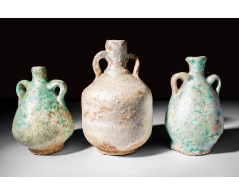 Ca. 30 BC - AD 100A group of three Egypto-Roman green glazed amphoriskoi. The first and the last vessels exhibit a large pear