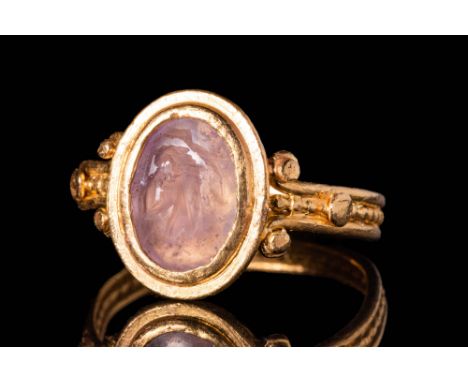 Ca. AD 50 - 200A Roman oval amethyst intaglio depicting a busto of an eagle facing left. The intaglio is set in a high carat,