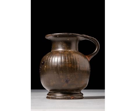 Ca. 450 - 380 BCA black-glazed pottery oinochoe with a globular body with vertical ribbing adorning the body and the shoulder