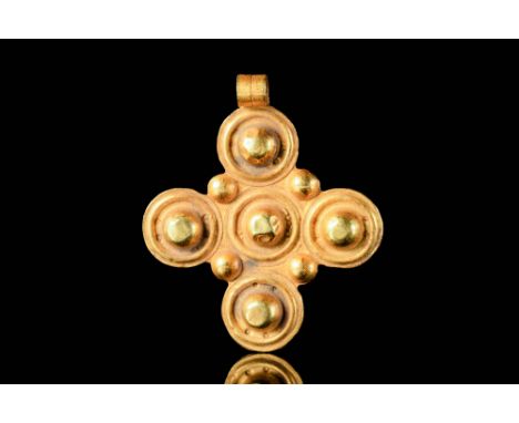 Ca. AD 700 - 900A Byzantine gold cross-shaped pendant decorated with moulded five dots/circles on the arms and in the centre 