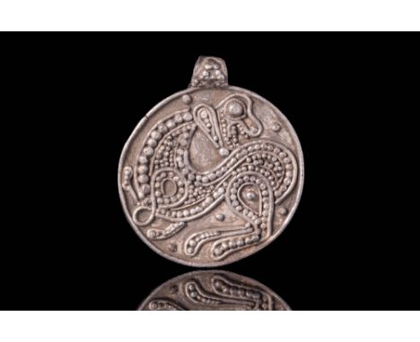 Ca. AD 800 - 1100A Viking silver pendant of circular form with a griffin and symmetrical geometric composition featuring a re