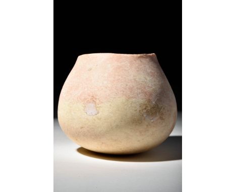 Ca. 3000 - 2000 BCA nice jar carved from pink stone with white inclusions. The vessel sits on a rounded base, and it features