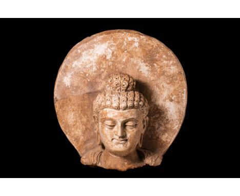 Ca. AD 300 - 480An impressive molded stucco Buddha head. The serene face composes of deep set eyes loking downwards, accentua
