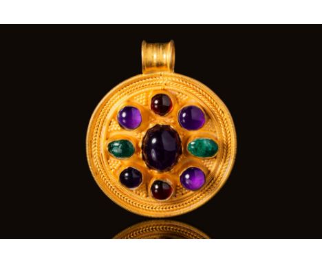 Ca. AD 400 - 800 An Early Medieval gold circular pendant. The pendant has a large central oval amethyst cabochon, with 8 smal