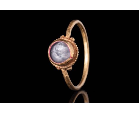 Ca. AD 300 - 400A Roman gold ring with a simple and elegant round hoop connected to a round bezel with two gold pellets on ea
