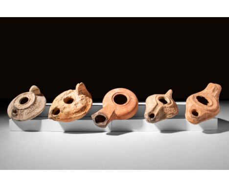 Ca. AD 400 - 600 A set of five mould-formed pottery oil lamps, four with pierced handles and one with solid handles. Two of t