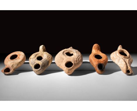 Ca. AD 400 - 600 A set of five mould-formed pottery oil lamps, four with solid handles and one with no handle. Two of the lam
