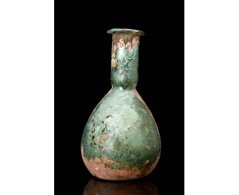 Ca. AD 100 - 300A Roman green glass unguentarium with a pear-shaped body, a long, tapering neck, a flared spout, and a folded