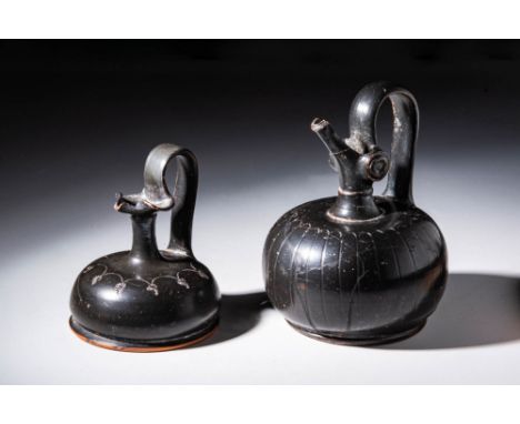 Ca. 350 - 300 BCA pair of Apulian black-glazed epichysis. The first is embellished with incised leaves on the shoulders, the 
