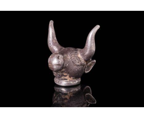 Ca. 600 - 500 BCAn Achaemenid silver pendant depicting a bull's head with incised eyes, a bulbous snout, a broad brow, and a 