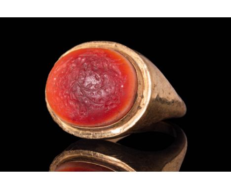 Ca. AD 50 - 200A Roman glass intaglio depicting a tree with phalluses in possibly later gold ring, formed from a round hoop w