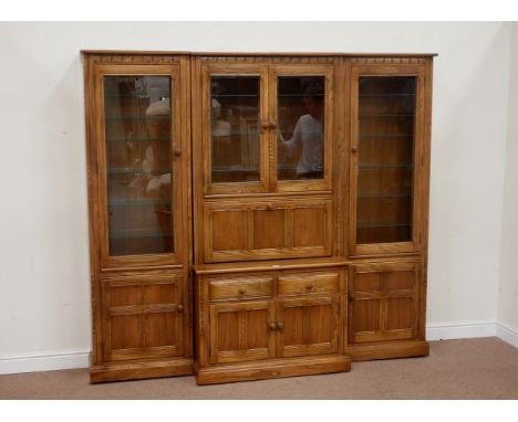 Ercol 'Mural' elm golden dawn breakfront wall display cabinet, centre fall front compartment above three drawers and double c