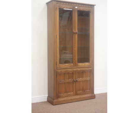 Ercol 'Mural' elm golden dawn display cabinet, enclosed by two bevel glazed door, above double cupboard, W97cm, H196cm, D34cm