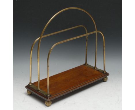 An early 20th century oak and brass periodical rack, arched central division, ribbed knop feet, 35cm wide, c.1910 