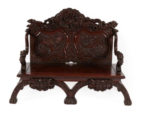 A Japanese Carved Hardwood Bench, late 19th/early 20th century, the back support profusely carved with a dragon above two mou